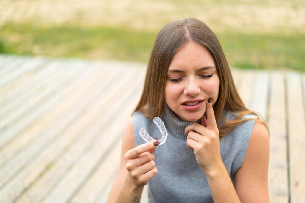 Mujer sujetando su férula de descarga transparente para el bruxismo