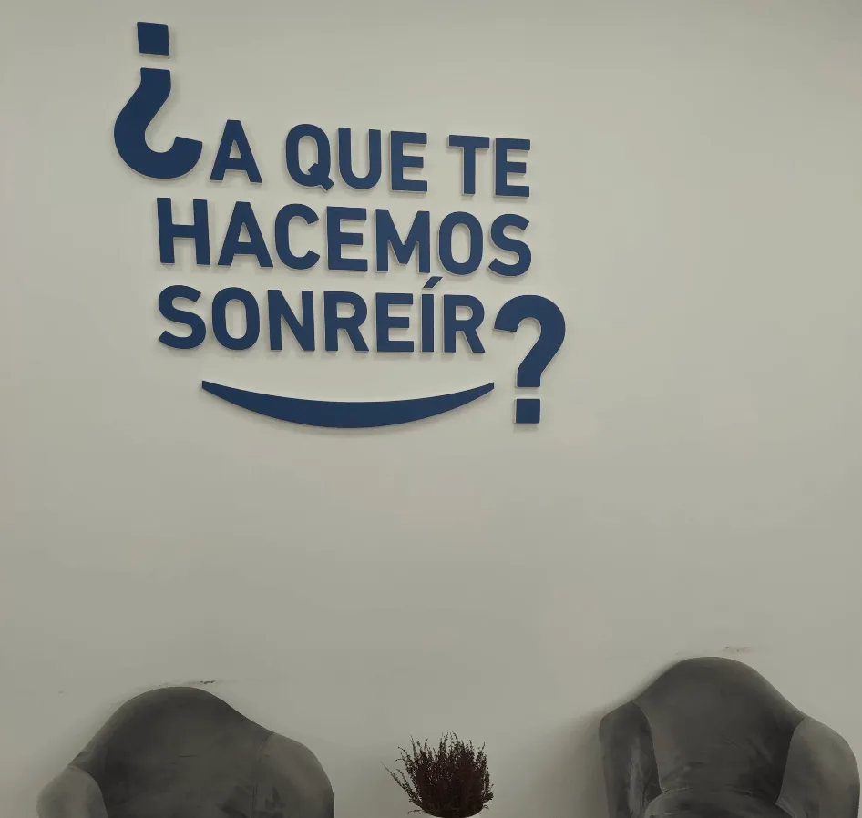 Clínica dental en Alcorcón con el lema «¿A que te hacemos sonreír?» en la pared