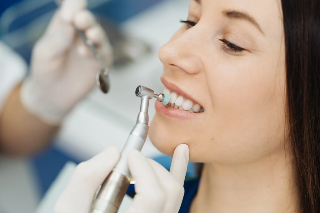 Paciente sonriendo durante el pulido de una limpieza dental profesional