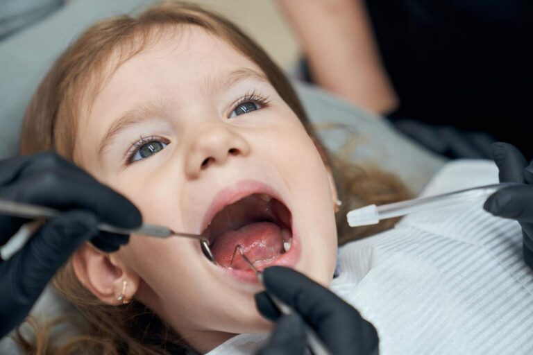 Niña con la boca abierta durante una revisión dental infantil