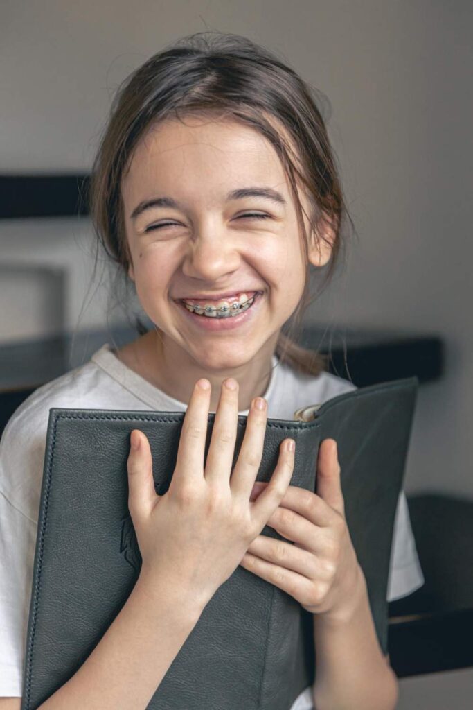Niña sonriendo con brackets metálicos