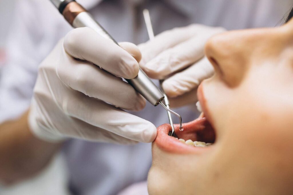 Dentista revisando los dientes y las encías de un paciente