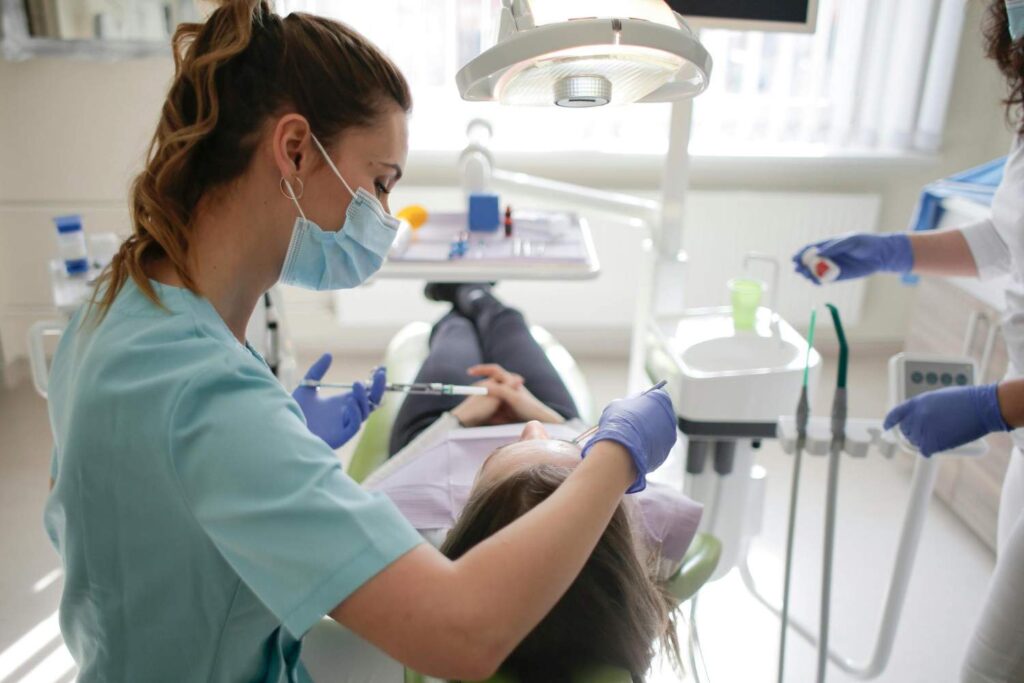 Dentista atendiendo a una paciente en un gabinete dental