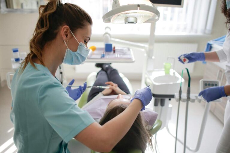 Dentista atendiendo a una paciente en un gabinete dental